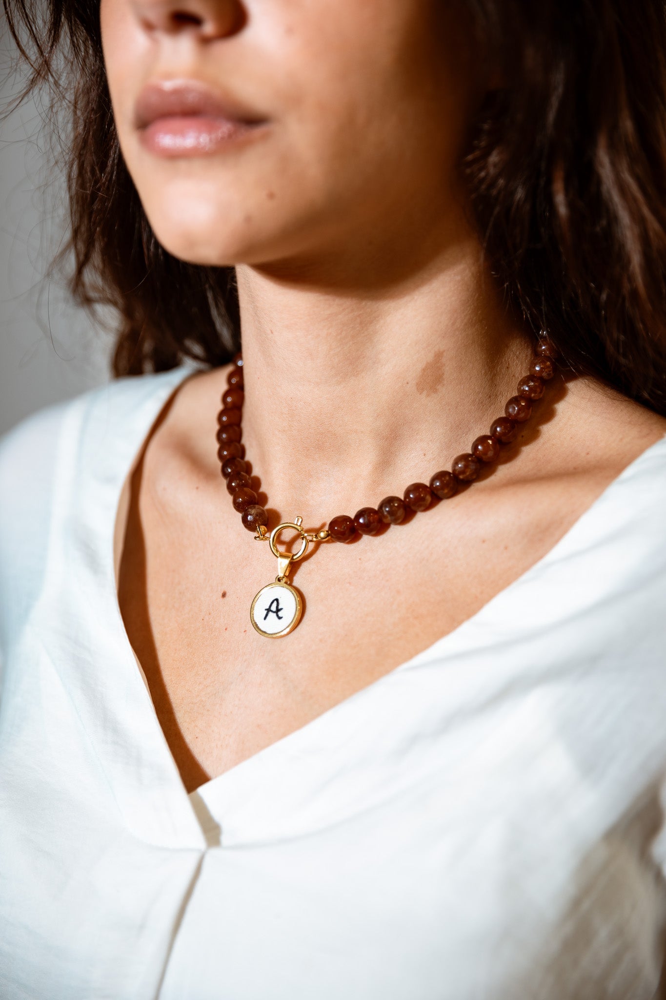 Colar de pérolas com letra bordada