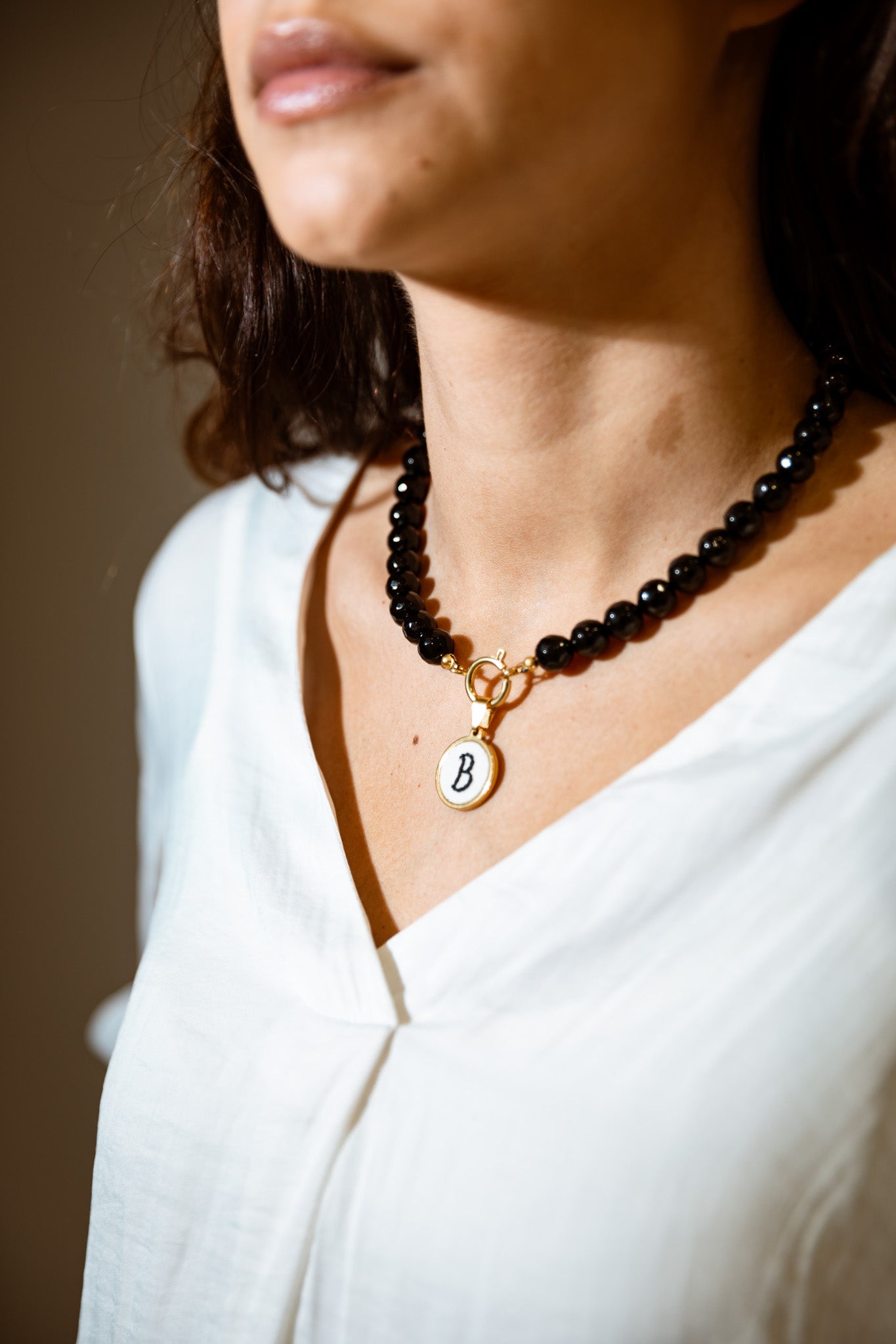 Colar de pérolas com letra bordada