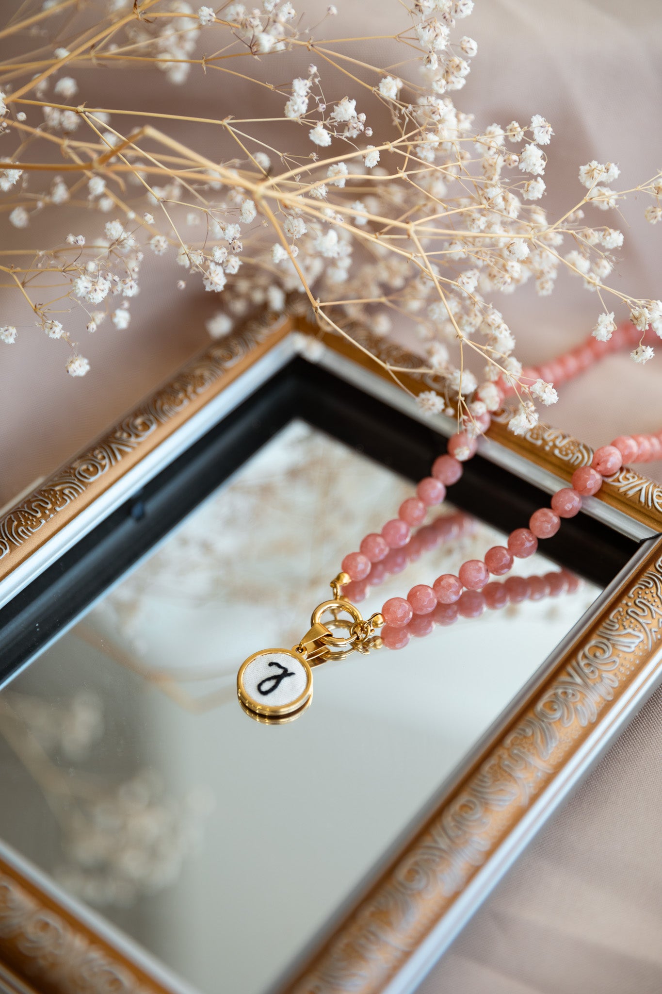 Colar de pérolas com letra bordada